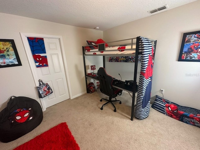 bedroom with light colored carpet and a textured ceiling