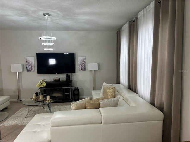 living room featuring carpet floors, a textured ceiling, and a fireplace