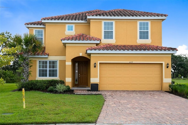 mediterranean / spanish house featuring a garage and a front lawn