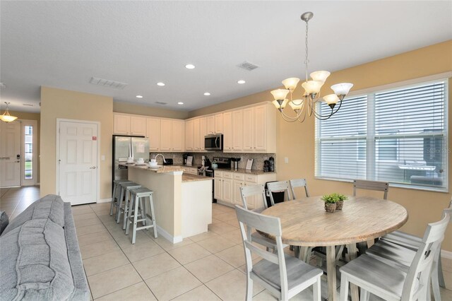 tiled dining space with a wealth of natural light and a chandelier