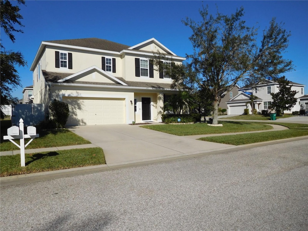 view of property featuring a front yard and a garage