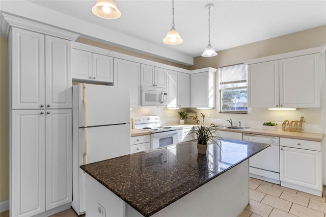 kitchen with light tile patterned flooring, dark stone countertops, white cabinets, a center island, and white appliances