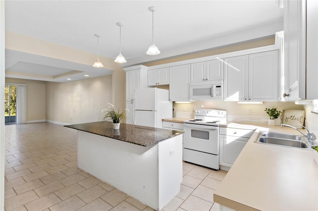 kitchen with white cabinetry, white appliances, a raised ceiling, and a kitchen island