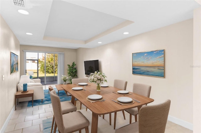 dining space with a raised ceiling