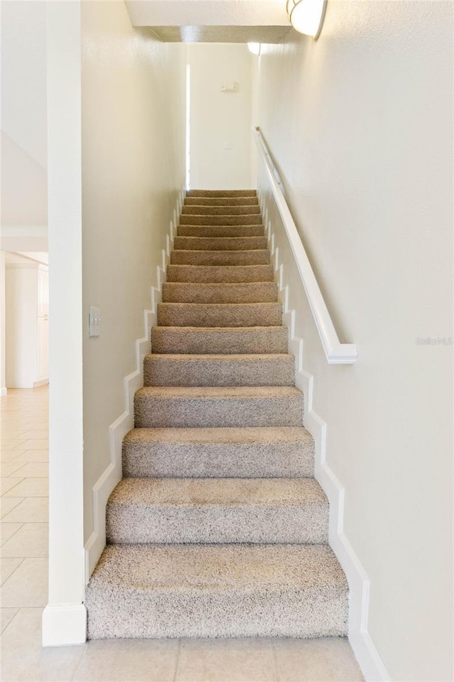 stairway featuring tile patterned flooring