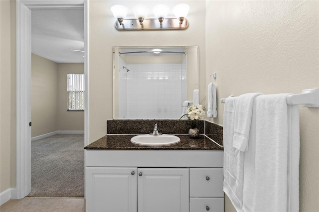 bathroom featuring walk in shower and vanity