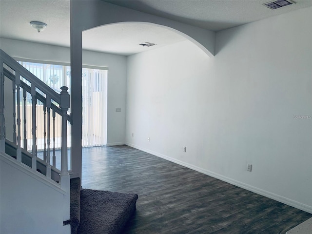 interior space featuring dark wood-type flooring and a textured ceiling