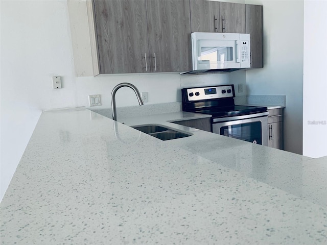 kitchen with stainless steel electric range, sink, and light stone counters