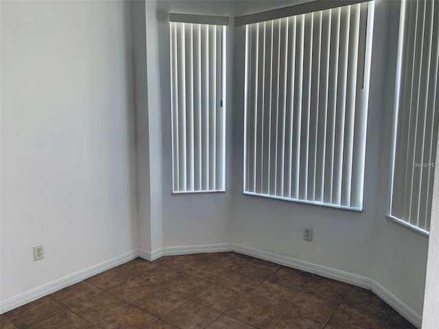 empty room featuring dark tile patterned floors