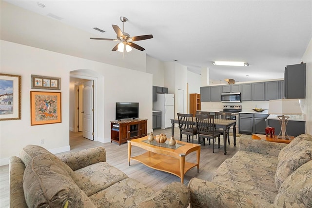 living room featuring lofted ceiling, ceiling fan, and light hardwood / wood-style floors