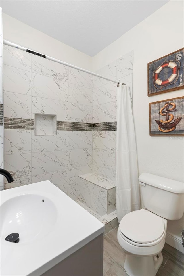 bathroom featuring toilet, sink, and curtained shower