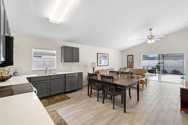 dining space with vaulted ceiling, a wealth of natural light, light hardwood / wood-style floors, and sink