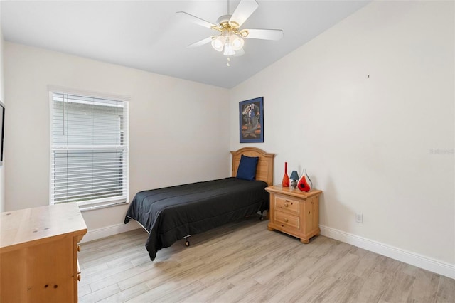 bedroom with ceiling fan, light hardwood / wood-style floors, multiple windows, and vaulted ceiling