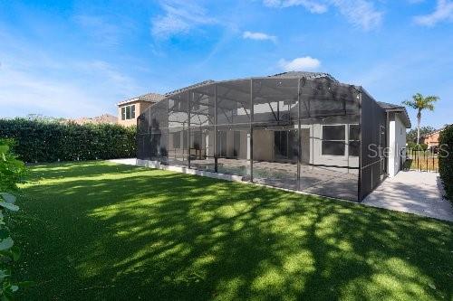 rear view of house featuring a lanai, a yard, and a patio