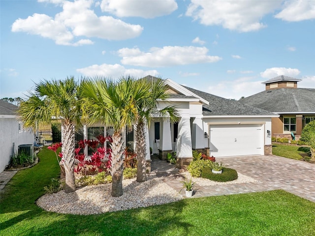 view of front of home featuring a garage, a front lawn, and central air condition unit