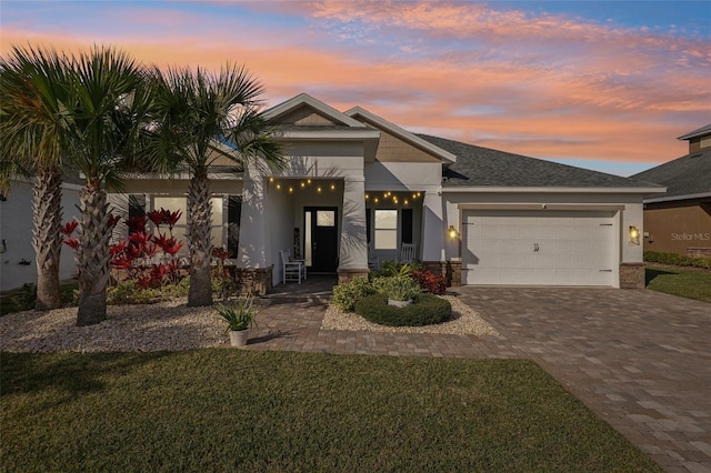 view of front of house featuring a garage and a lawn