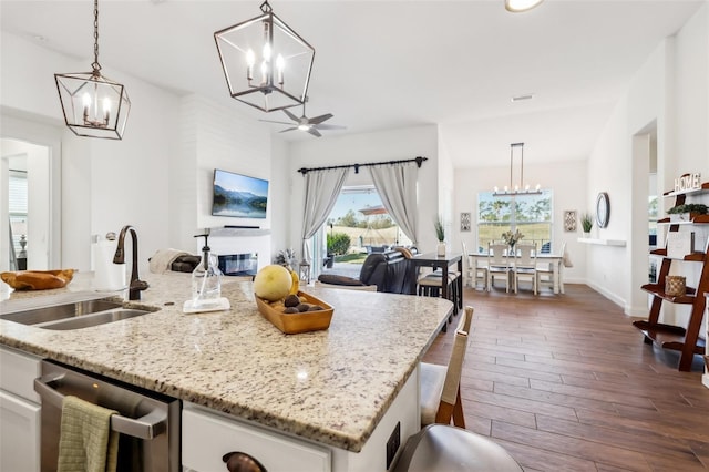 kitchen featuring sink, a center island with sink, pendant lighting, and stainless steel dishwasher