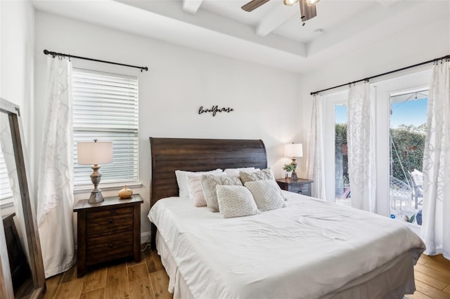 bedroom featuring hardwood / wood-style flooring, access to exterior, beamed ceiling, and ceiling fan