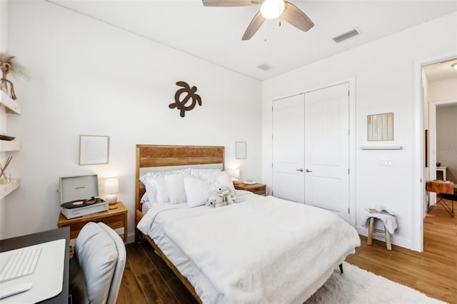 bedroom featuring ceiling fan, dark wood-type flooring, and a closet