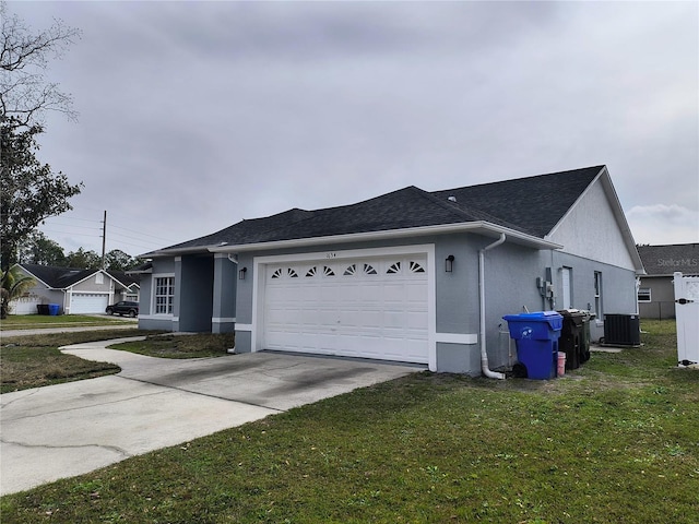 view of side of property featuring a lawn, cooling unit, and a garage