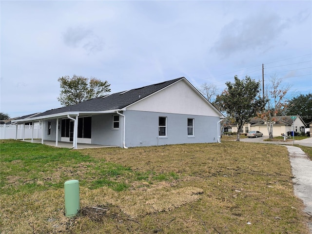 view of side of property with a yard and a patio