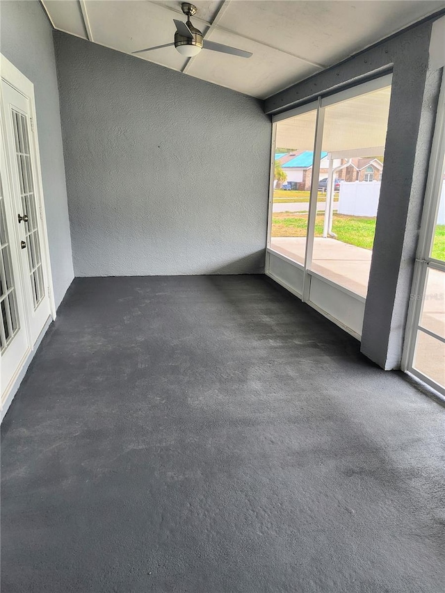 unfurnished sunroom with ceiling fan