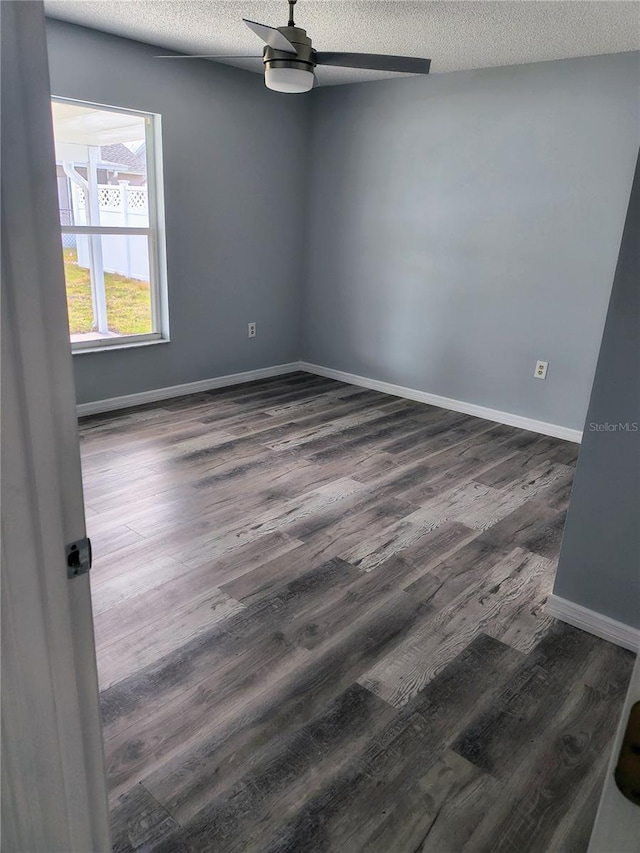 spare room with ceiling fan, dark wood-type flooring, and a textured ceiling