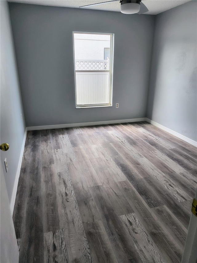 empty room featuring ceiling fan and dark hardwood / wood-style flooring