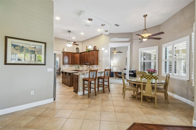 tiled dining area with a towering ceiling and ceiling fan