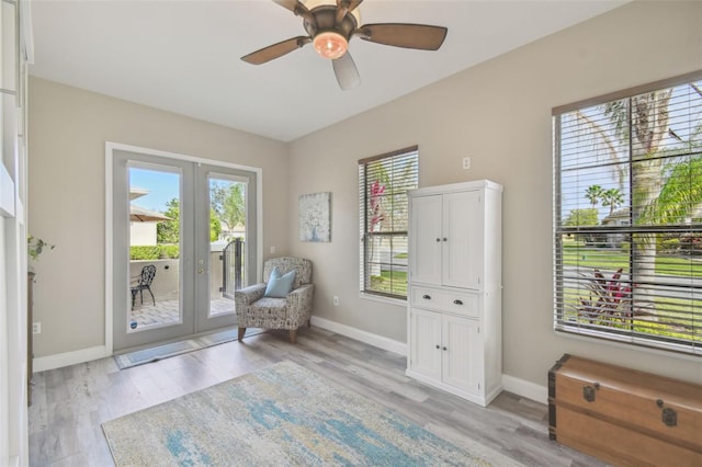 living area with french doors, ceiling fan, and light hardwood / wood-style floors