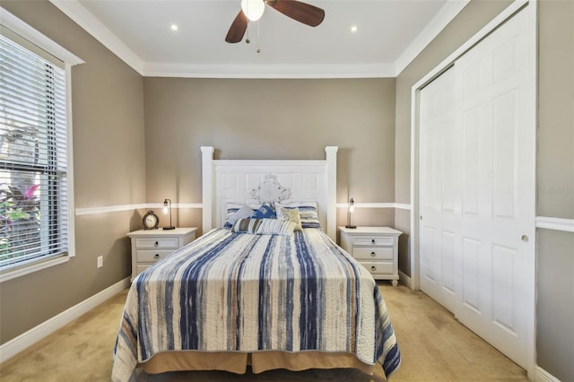 carpeted bedroom featuring ornamental molding, ceiling fan, and a closet