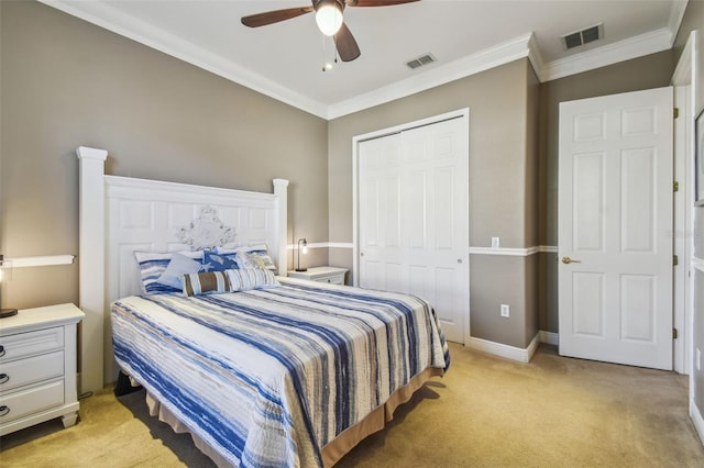 carpeted bedroom featuring ornamental molding, a closet, and ceiling fan