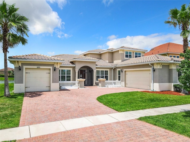 mediterranean / spanish-style home with a garage and a front yard