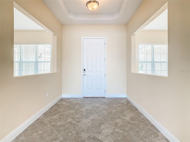 entrance foyer featuring a raised ceiling and a healthy amount of sunlight