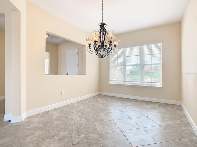 tiled empty room with a notable chandelier