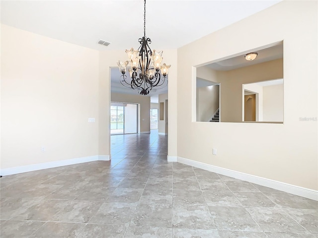 spare room featuring a chandelier