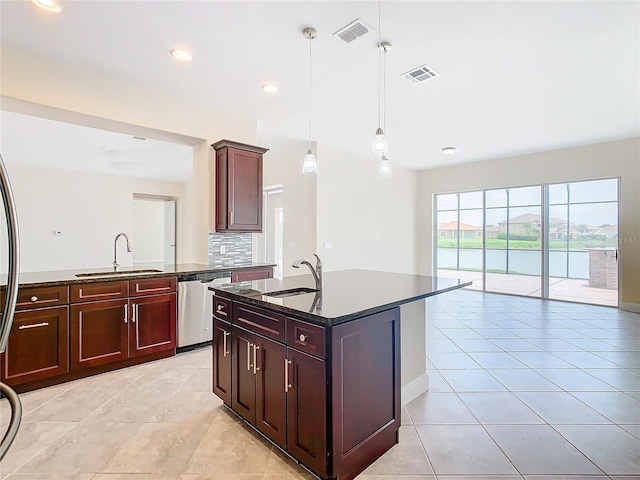 kitchen with sink, pendant lighting, stainless steel dishwasher, and an island with sink