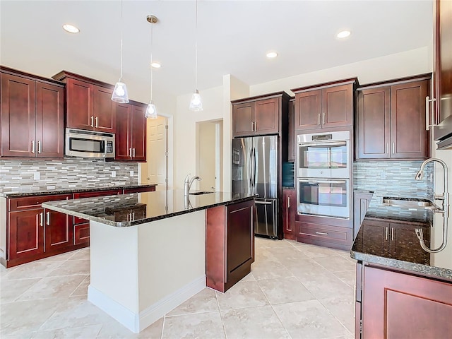 kitchen featuring backsplash, appliances with stainless steel finishes, dark stone counters, and a center island