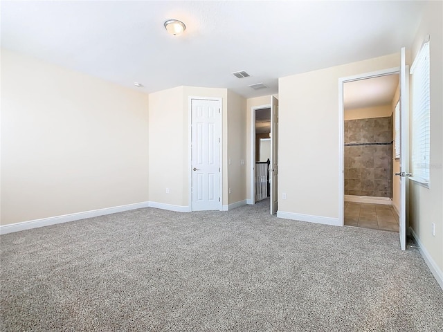 unfurnished bedroom with ensuite bathroom, a closet, and light carpet