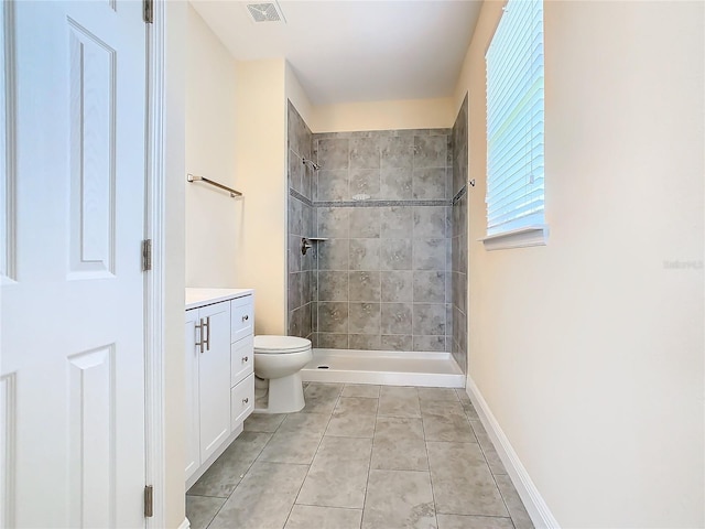 bathroom with tile patterned floors, toilet, vanity, and tiled shower