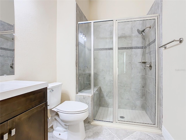 bathroom featuring toilet, tile patterned floors, a shower with shower door, and vanity