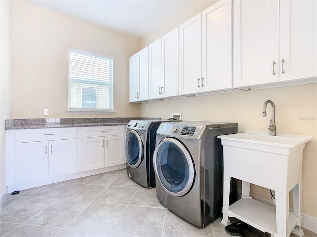 laundry area featuring sink, light tile patterned flooring, washer and dryer, and cabinets