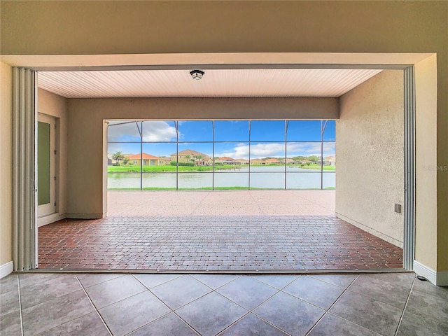 interior space with a water view and tile patterned floors