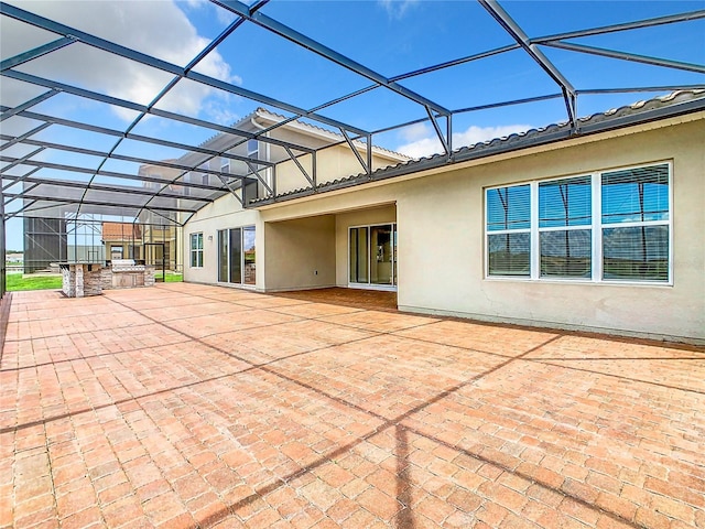 rear view of house featuring a lanai, an outdoor kitchen, and a patio