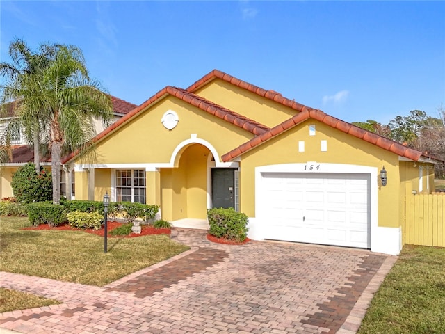 mediterranean / spanish-style home featuring a front yard and a garage