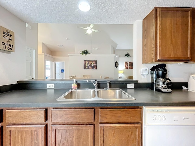 kitchen featuring sink, ceiling fan, white dishwasher, and a textured ceiling