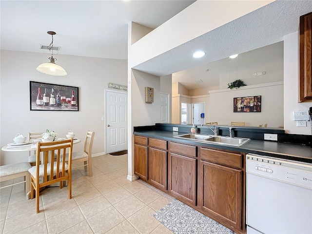 kitchen featuring dishwasher, decorative light fixtures, sink, vaulted ceiling, and light tile patterned floors