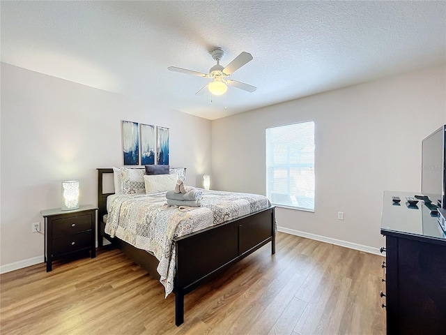 bedroom with a textured ceiling, light hardwood / wood-style flooring, and ceiling fan