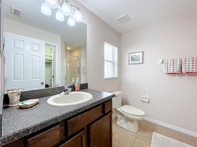 bathroom with vanity, toilet, a shower with shower door, and tile patterned flooring