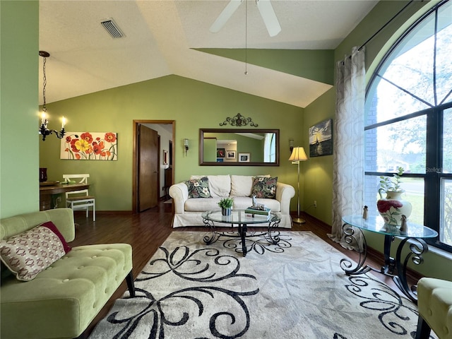 living room featuring vaulted ceiling, a healthy amount of sunlight, ceiling fan with notable chandelier, and hardwood / wood-style floors